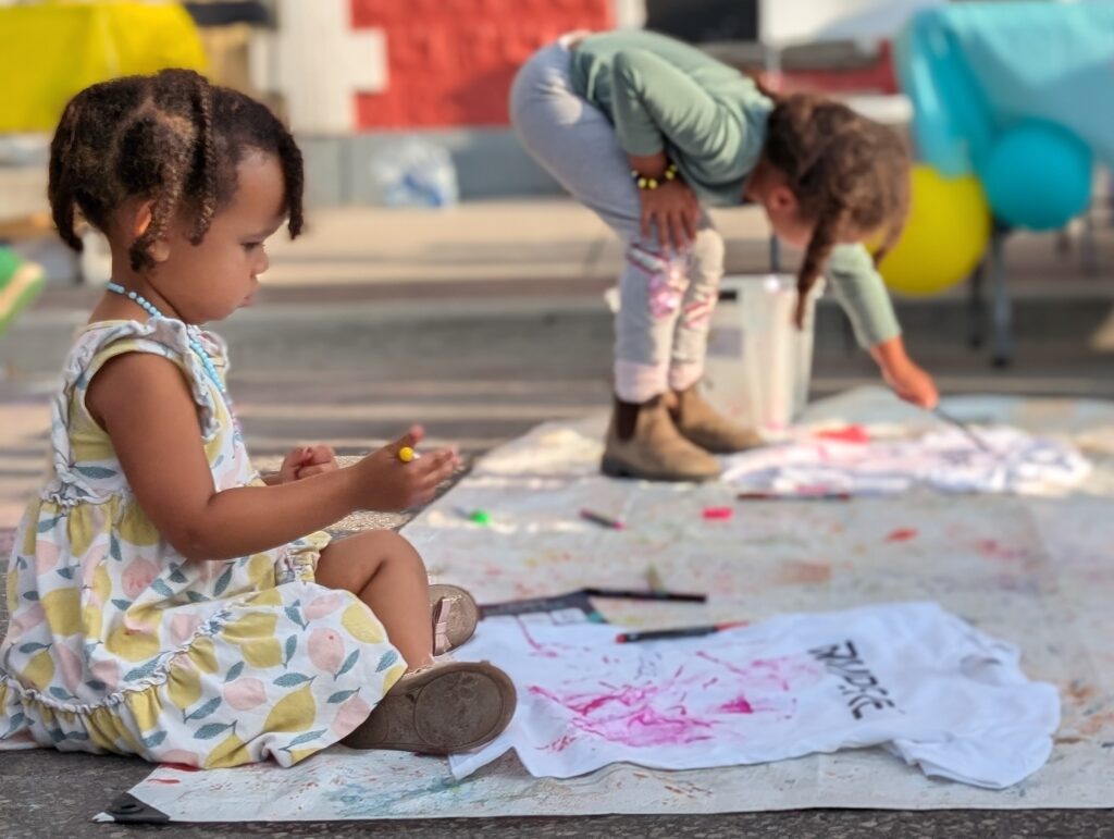 Two children drawing on Ampere T-shirts, displaying their artistic ability.
