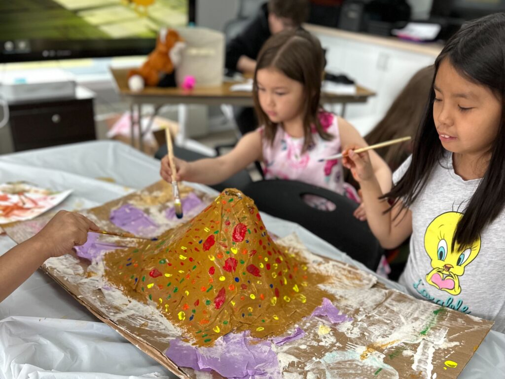 img_1090 cropped Children in the makerspace, painting a volcano science project.