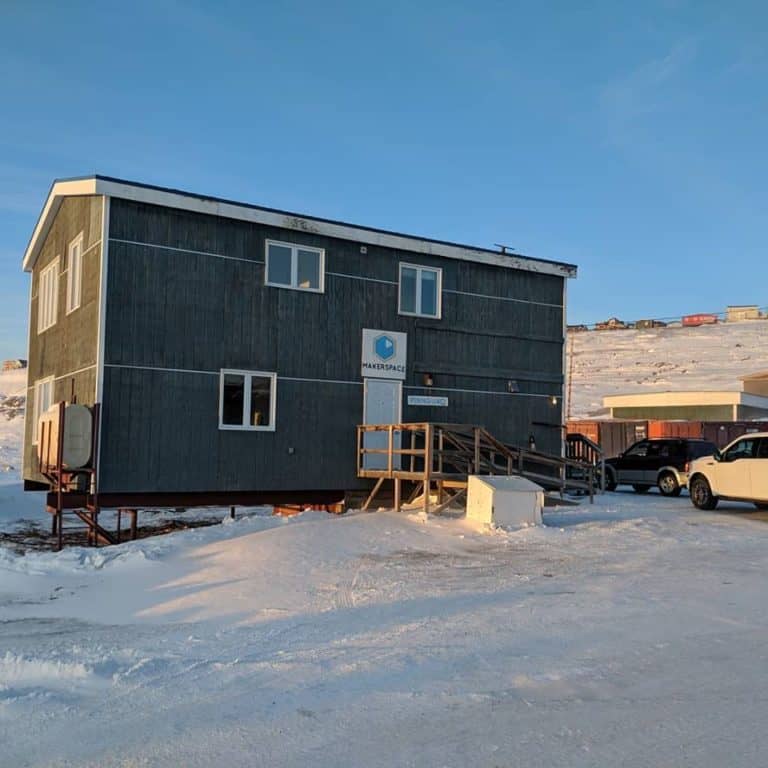 A dark building with snow on the ground
