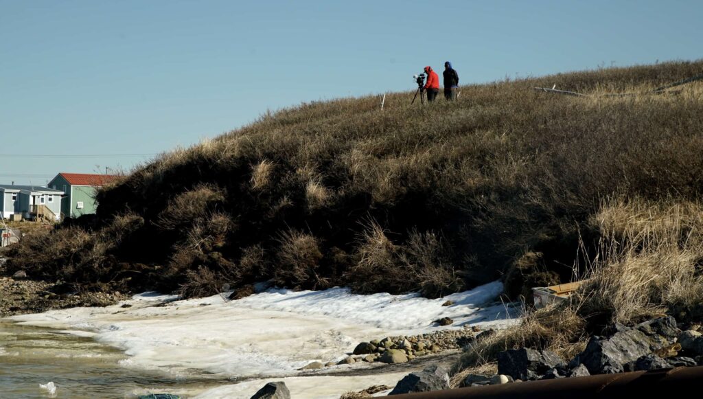 people standing on top of a grass hill
