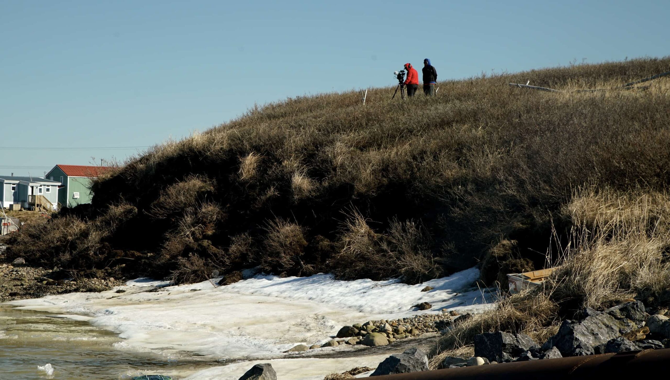 people standing on top of a grass hill