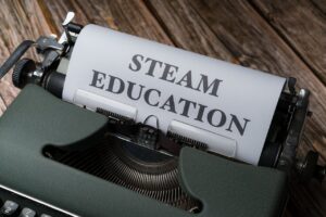 Retro typewriter with 'STEAM Education' paper, symbolizing creativity and innovation.