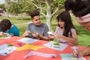 Kids engage in creative crafts outdoors during a fun and educational summer camp.